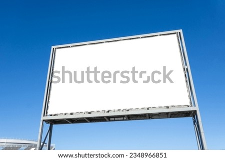 Large horizontal blank advertising poster billboard banner mockup in front of building in urban city, installed freestanding