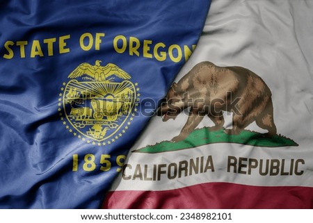 big waving colorful national flag of california state and flag of oregon state . macro