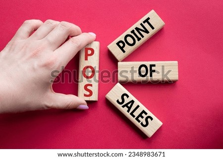 POS - Point Of Sales symbol. Wooden cubes with words POS. Businessman hand. Beautiful red background. Business and POS concept. Copy space. Concept word