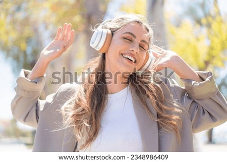 Pretty blonde Uruguayan woman listening music and dancing
