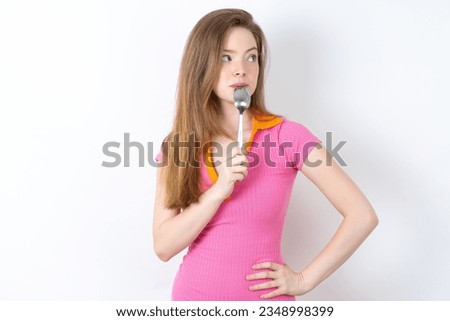 Very hungry young beautiful red haired woman holding spoon into mouth dream of tasty meal