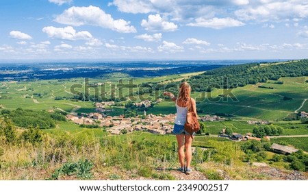 traveler woman poiting green vineyard and village panoramic view in Burgundy- France