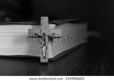 A small wooden crucifix next to the Holy Bible