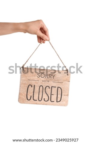 Female hand holding sign with text SORRY WE'RE CLOSED on white background Royalty-Free Stock Photo #2349025927