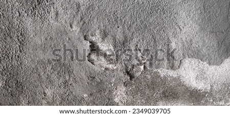 photo of rough surface of house wall with peeling gray paint.