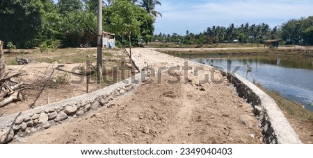 photo of a retaining embankment for road construction in a rural area.