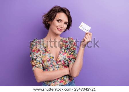 Photo portrait of attractive young woman hold white credit card dressed stylish flower print clothes isolated on purple color background