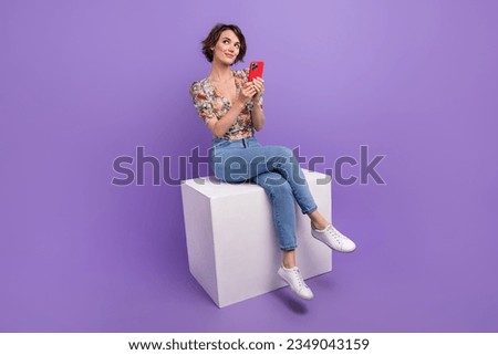 Full body portrait of minded creative lovely lady sit podium hold smart phone look empty space isolated on purple color background