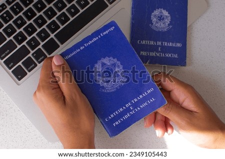 Brazil Work Card. Translation - Federative Republic of Brazil, Ministry of Labor. Brazilian work card in front of a laptop, illustrating the relationship between legal documentation and the job market