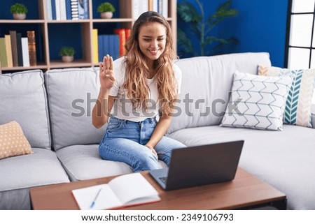 Young beautiful hispanic woman having video call communicate with sign deaf language at home