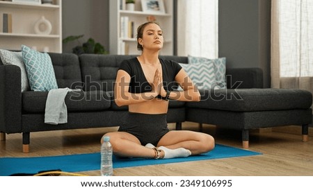 Young beautiful hispanic woman training yoga relaxed at home