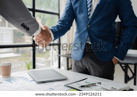 Two business men shake hands, Two businessmen are agreeing on business together and shaking hands after a successful negotiation. Handshaking is a Western greeting or congratulation. Royalty-Free Stock Photo #2349126211