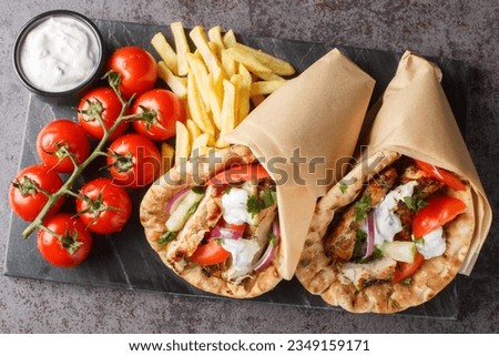 Gyros souvlaki wrapped in a pita bread closeup on the board on the table. Horizontal top view from above
 Royalty-Free Stock Photo #2349159171