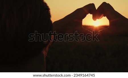Her mind heart flowing happiness freedom, chasing dream basks orange glow sunset sky. romantic concept love beautifully shaped she holds hands with her valentine, making gesture shows symbol love park