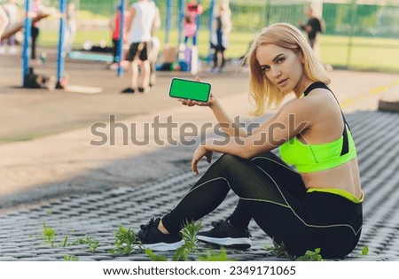 Tired fitness woman after workout and use smartphone with green screen