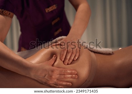 Experienced massotherapist giving buttock massage to patient