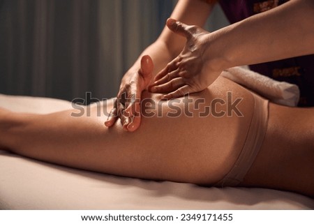 Experienced massotherapist giving anti-cellulite massage to client