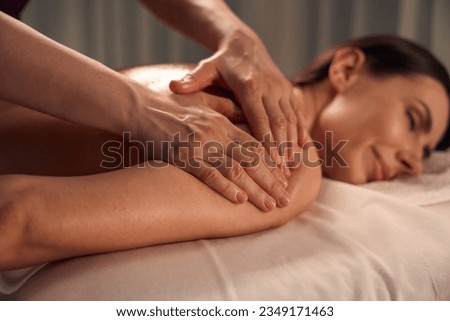 Spa patient sleeping during upper arm massage session Royalty-Free Stock Photo #2349171463