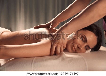 Masseuse massaging trigger point on client shoulder blade Royalty-Free Stock Photo #2349171499