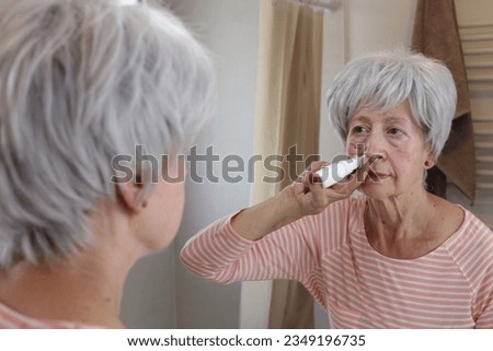 Senior woman using a nasal spray   Royalty-Free Stock Photo #2349196735