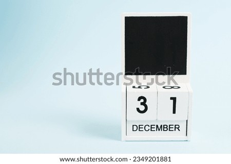 New Year, wooden calendar with the date December 31 on a blue background with copy space. The concept of preparing for the celebration of Christmas and New Year and plans for the future