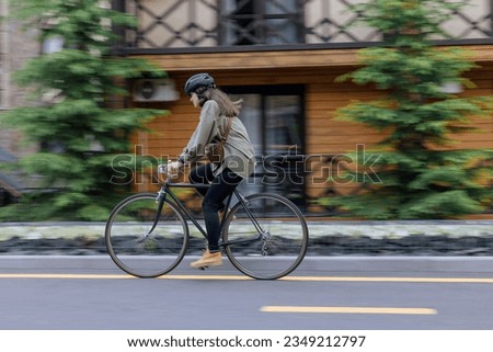 Woman rides bicycle fast in the street with blurred in motion background