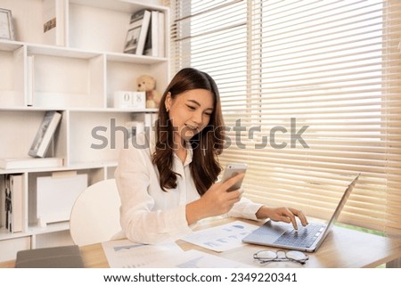 Young business woman working in front of the computer, Use mobile phones, Happy home life, Work from home.