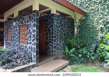 Cimahi, Indonesia - July 16, 2023: An architectural design of a toilet or bathroom with an outdoor theme that uses decorative stone walls and leaves