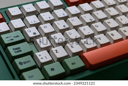 Close up photo of a computer keyboard. Computer keyboard with green, orange and white buttons. Selective Focus.