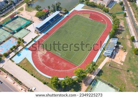 Aerial top view of soccer football sport recreation field ground, national stadium with university or college school campus buildings. Urban city town in Asia. Green court arena. Royalty-Free Stock Photo #2349225273