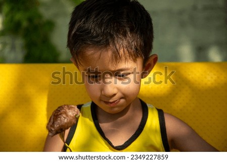 a child eating a chicken leg in a spoon