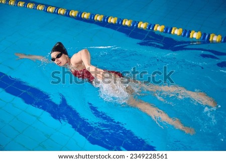 Swimmer demonstrating front crawl style during photo shoot in water