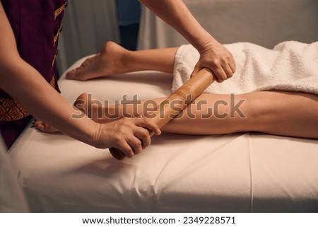 Spa therapist giving calf massage to adult woman