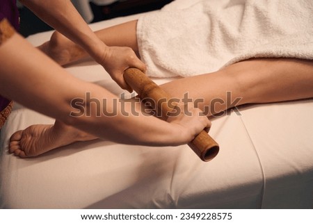 Experienced masseuse giving leg massage to client