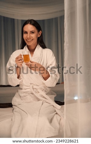 Happy spa client posing for camera with herbal beverage Royalty-Free Stock Photo #2349228621