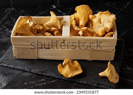 Fresh Chanterelles in Wooden Box, Black Background