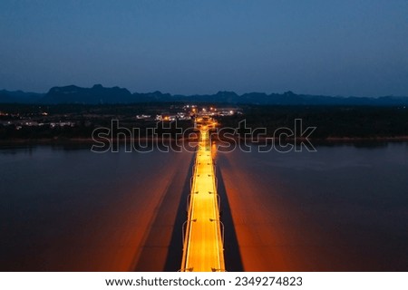Aerial view of Thai Laos bridge with Mekong River with green mountain hill at night. Nature landscape background in Ubon Ratchathani, Thailand. Royalty-Free Stock Photo #2349274823