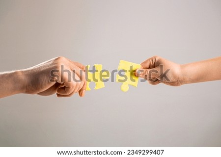 Mens and childs hands connecting puzzles. Hands connecting puzzle. Puzzles. Hand of the child and hand of mother fold puzzle, closeup. Hands hold puzzles. Solution of problems. Royalty-Free Stock Photo #2349299407