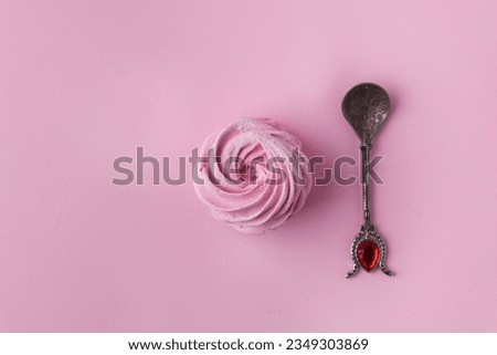 Pink berry homemade marshmallow. Zefir dessert with red currant mousse on the pink pastel background next to vintage tea spoon. Flat lay