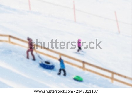 Children pulls toboggans on snowy slope at ski resort, winter leisure, active lifestyles, childhood, Christmas. Happy hobby