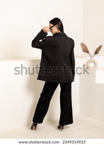 Woman in black oversize jacket. Classic women's suit for office, school, university, business meetings. Back view Royalty-Free Stock Photo #2349314923