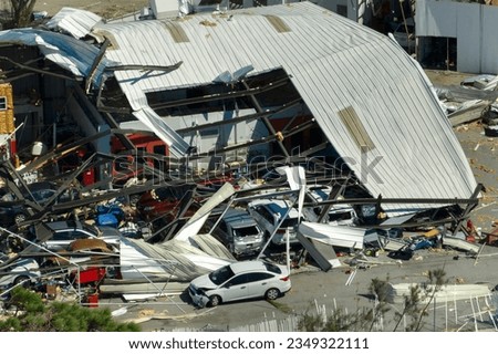 Automotive workshop destroyed by hurricane wind with damaged cars under ruins in Florida. Consequence of natural disaster Royalty-Free Stock Photo #2349322111