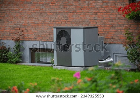 Air heat pump installed on the exterior facade of the old house. Sustainable heating solutions for old construction. Air source heat pump beside residential country cottage. Royalty-Free Stock Photo #2349325553
