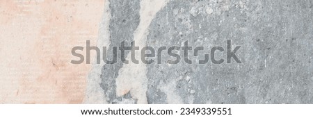 Torn old faded paper wallpaper with a retro pattern. Tattered scraps of paper on a concrete wall. Vintage texture for background and design. Closeup view with copy space. High resolution. Royalty-Free Stock Photo #2349339551