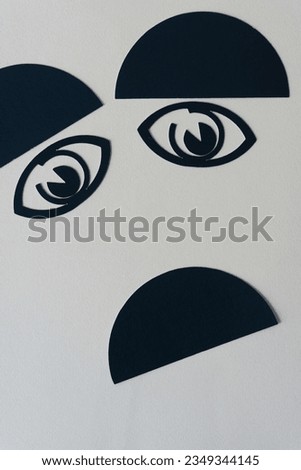 frowning alien or cartoon face with semi-circle eyebrows, machine-cut paper eyes, and an upside down semi-circle black shape unhappy mouth Royalty-Free Stock Photo #2349344145