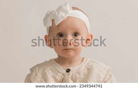 a small child on a white background for advertising. a portrait of a beautiful one-year-old girl in light clothes on a white background for advertising a service product.