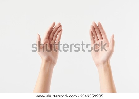 A woman's hand with separate symbolic movements on a white background, filming a high-definition studio