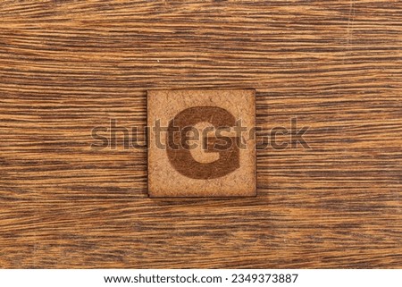 Capital Letter In Square Wooden Tiles - Letter G, On Wooden Background.