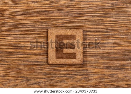 Capital Letter In Square Wooden Tiles - Letter E, On Wooden Background.