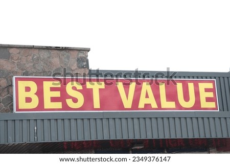 best value words caption text horizontal rectangle sign on storefront near bottom of frame in yellow on red background with sky behind